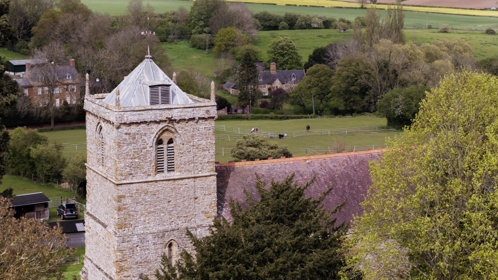Drone shot of church bell tower in Northamptonshire during a wedding
