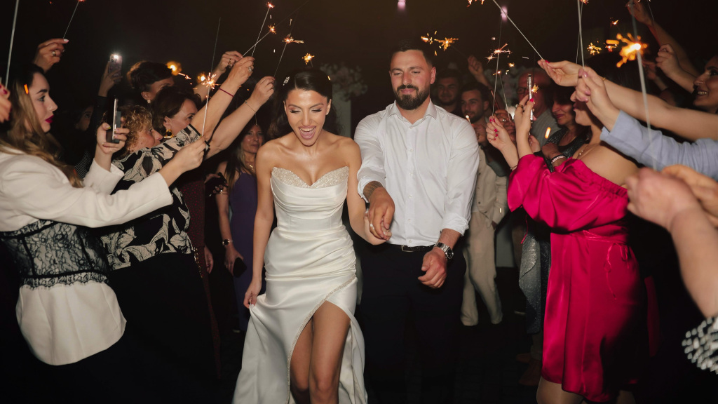 Wedding couple exit wedding in a sparkler arch